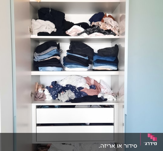 ארון בגדים עם מדפים מלאים בבגדים מקופלים ומבולגנים